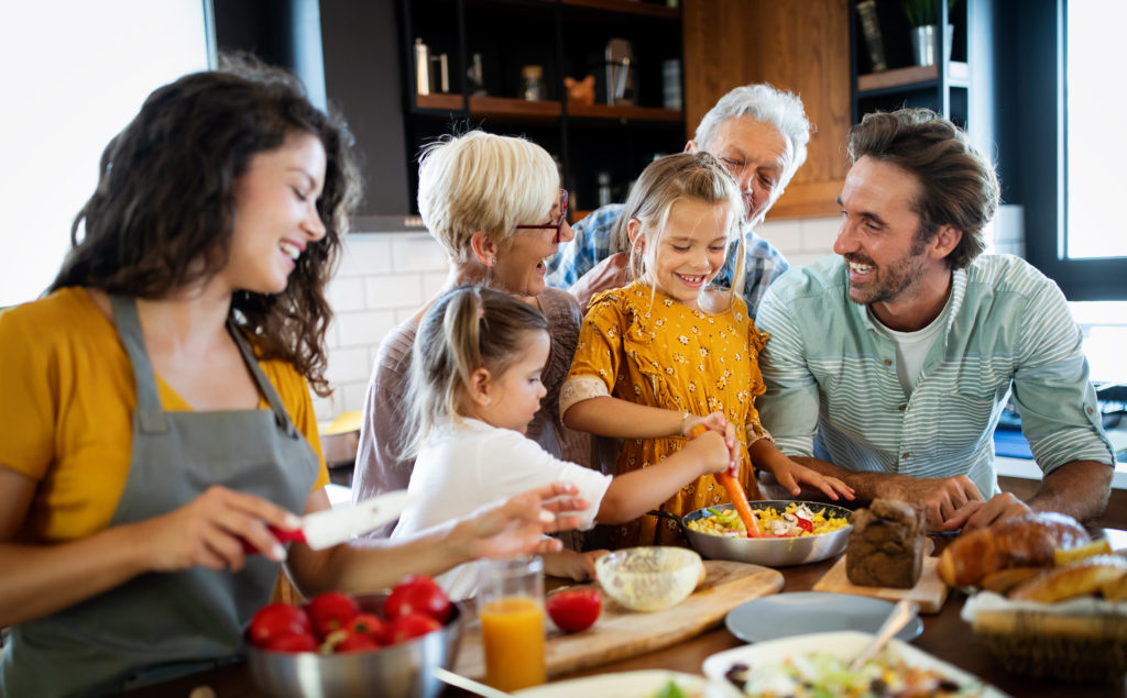 Cheerful happy family spending good time together while cooking in kitchen