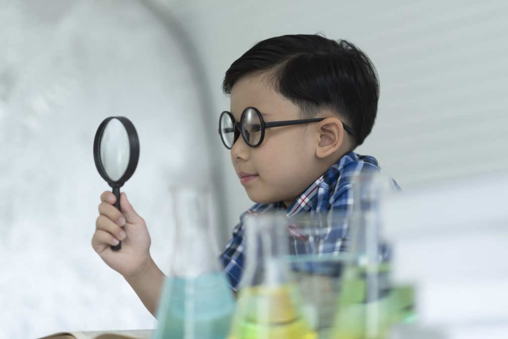 Children are studying science. Use the magnifying glass in the laboratory